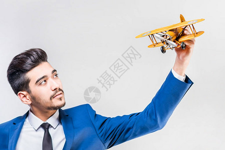 穿西装的有吸引力的男人持有模型飞机图片
