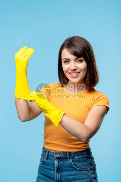 快乐的年轻女管家或清洁服务人员在会议室订购时手拿黄色橡皮手套图片