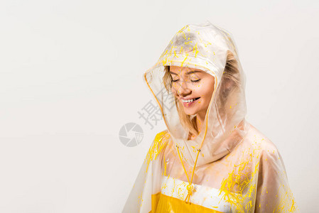 身穿雨衣和蒙面上涂有黄色涂漆的黄漆眼闭着眼睛的女士微笑背景图片