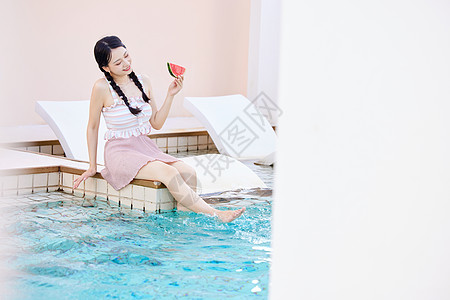 手拿西瓜在泳池边玩水的美女图片