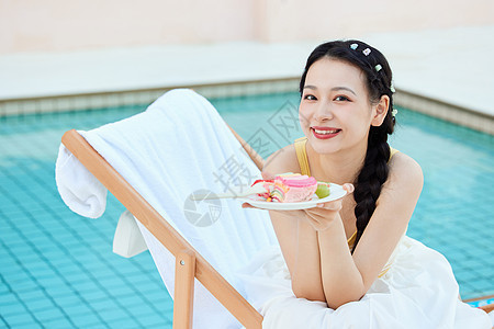 夏日美女在泳池边享受美食图片