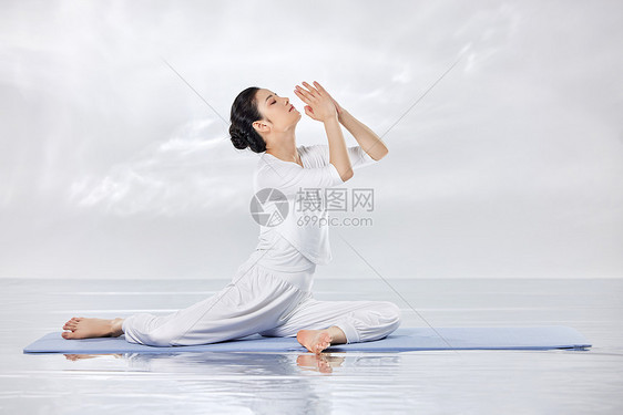 禅意水面上做瑜伽的青年女性图片