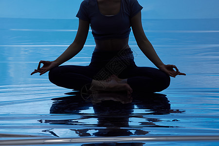 蓝色背景做瑜伽的女性剪影特写图片