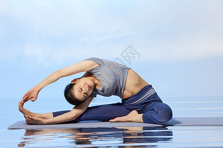 青年女性做瑜伽水面倒影图片