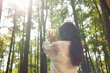 青年美女森林休闲散步背影图片