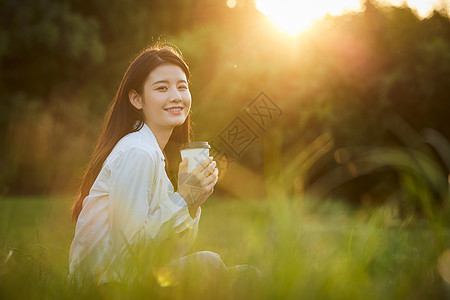 绿色长裙美女美女户外享受秋日阳光背景