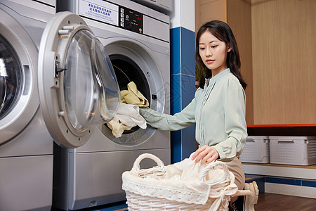 用洗衣机洗衣服的女青年图片
