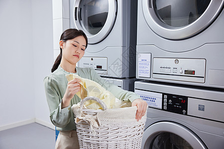 家用洗衣机洗衣服不开心的年轻女孩背景