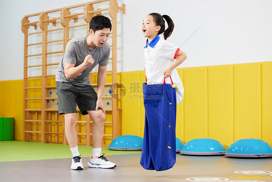 教练给练习跳跳袋的女孩加油鼓励图片