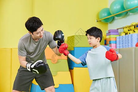 儿童手套教练带小男孩练习拳击背景