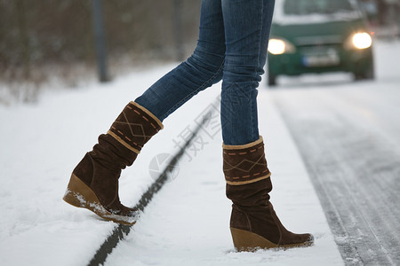 穿过雪路的妇女图片