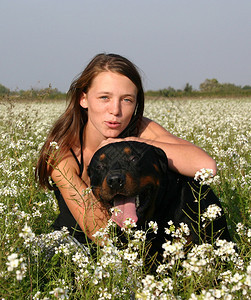 微笑的年轻女人和她的大黑狗图片