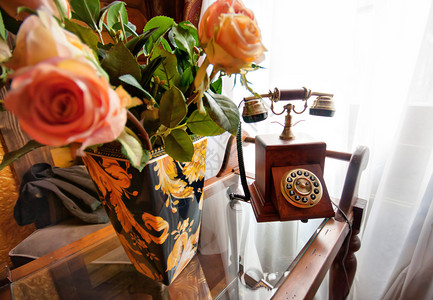 窗户旁边桌子上满玫瑰花朵的复图片