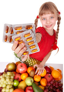 有水果和维生素药片的孩图片