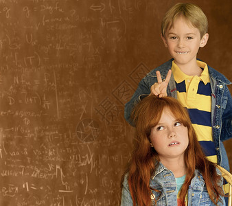 黑板前的红发女孩和金发男孩图片
