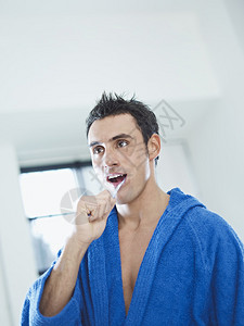 穿浴袍的成年男子在浴室刷牙垂直形状腰背景图片