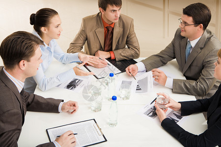 圆桌会议互动商业伙伴坐在办公桌旁的相交背景
