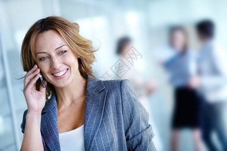 在工作环境中打电话的漂亮女商人的形象图片
