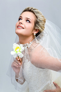 手捧兰花的现代新娘向上看的肖像图片