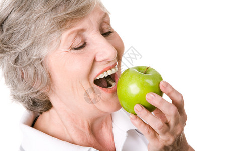 高龄妇女拿着苹果吃图片素材
