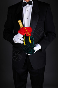 穿着燕尾服的绅士拿着香槟瓶装在节日礼物袋里图片