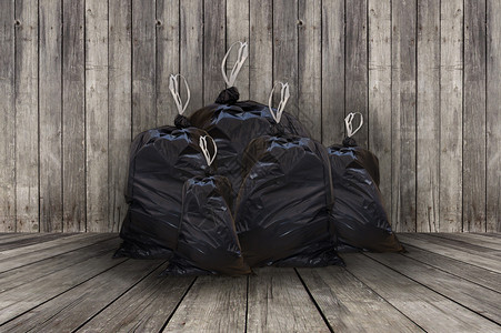 一堆木背景的全黑垃圾袋图片