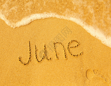 六月写在沙滩纹理上的沙子柔软的海浪图片
