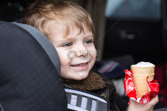 可爱的小孩男蓝眼睛在安全的汽车座椅图片