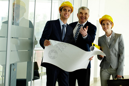 3名建筑设计师站在办公大楼里图片