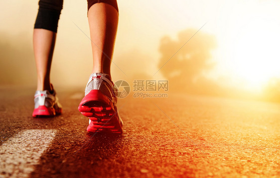 妇女健身日出慢跑概念在路边紧贴鞋图片