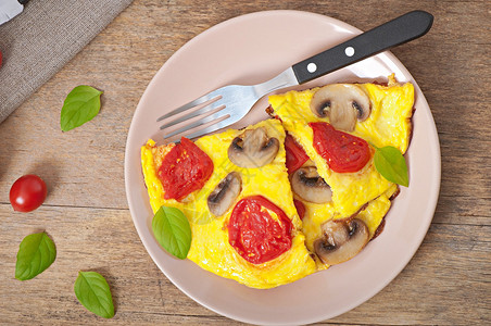 西红柿炒鸡蛋早餐美味的煎蛋卷配西红柿和蘑菇背景