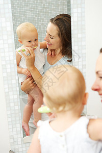 一位美丽的母亲教可爱的婴儿如何用牙图片