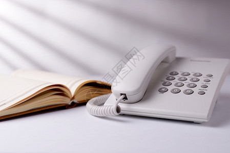 Landline电话拨打电话和公开笔记本或日记图片