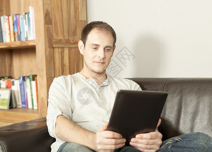 漂亮的秃顶中年男子在家舒适的皮沙发上放松图片