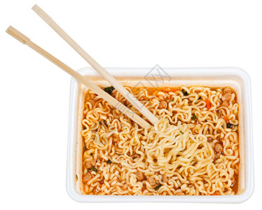 用木筷子从白色背景上隔离的泡沫帽吃准备好的方便面图片