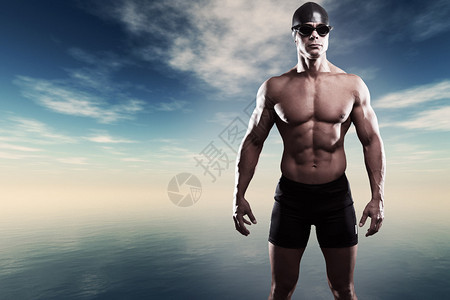 在蓝云的湖边带帽子和眼镜的混血游泳运动员极具图片