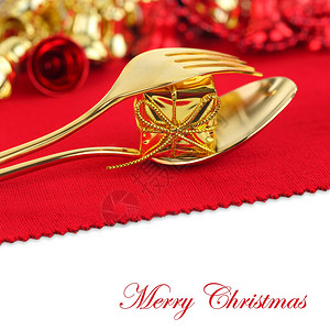 红色背景上带有装饰品的圣诞金色餐具图片