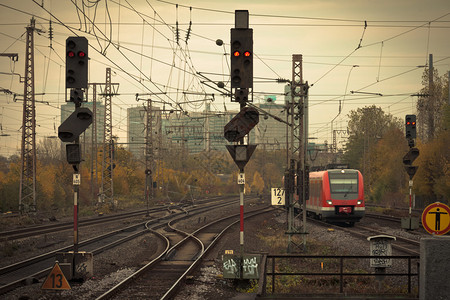 城市铁路轨道上一辆红色通班火车的图象图片