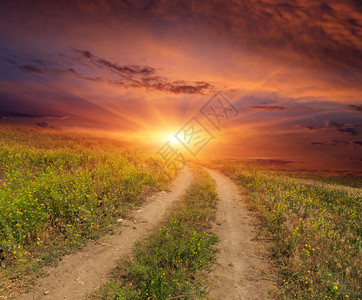 日落背景下草原上的道路图片