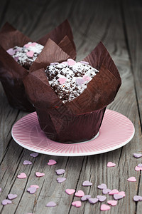 土制巧克力松饼黑木背景上含糖粉的自图片