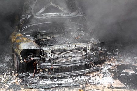 车库里一辆烧毁的汽车的特写照片图片