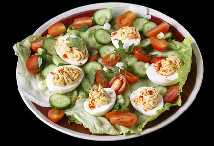 以生菜小西红柿切黄瓜和砍绿洋葱或扇贝为食用的魔鬼鸡蛋沙拉图片