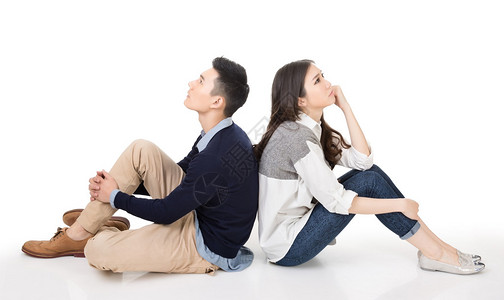 年轻亚洲情侣坐在背对的地上图片