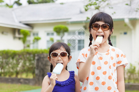 可爱的小女孩在他们家前吃冰淇淋图片