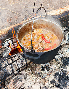 在篝火上用大锅煮炖牛肉汤图片
