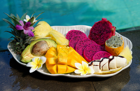 游泳池附近的热带异国水果篮子图片
