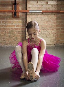 美丽的年轻芭蕾舞女郎准备上课当她在演播室穿上图片