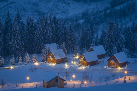 冬夜雪山中的小村庄背景图片