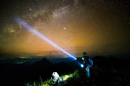 站在山上夜空的年轻人图片