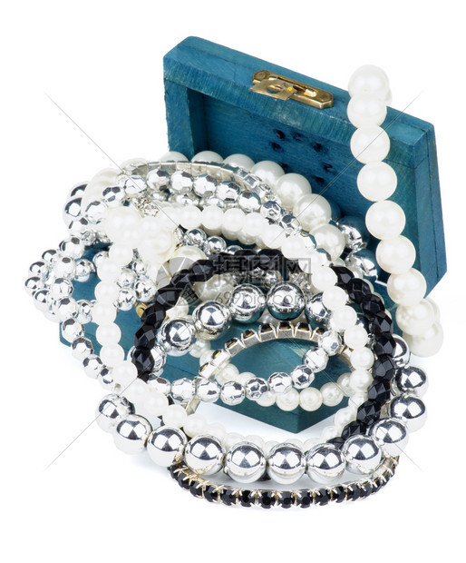 各种珍珠银和珠宝石夹在露天蓝木首饰花瓶中图片